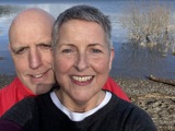 A photo of Christie patient Chris Thomasson-Dale and her husband Chris standing in front of a lake.