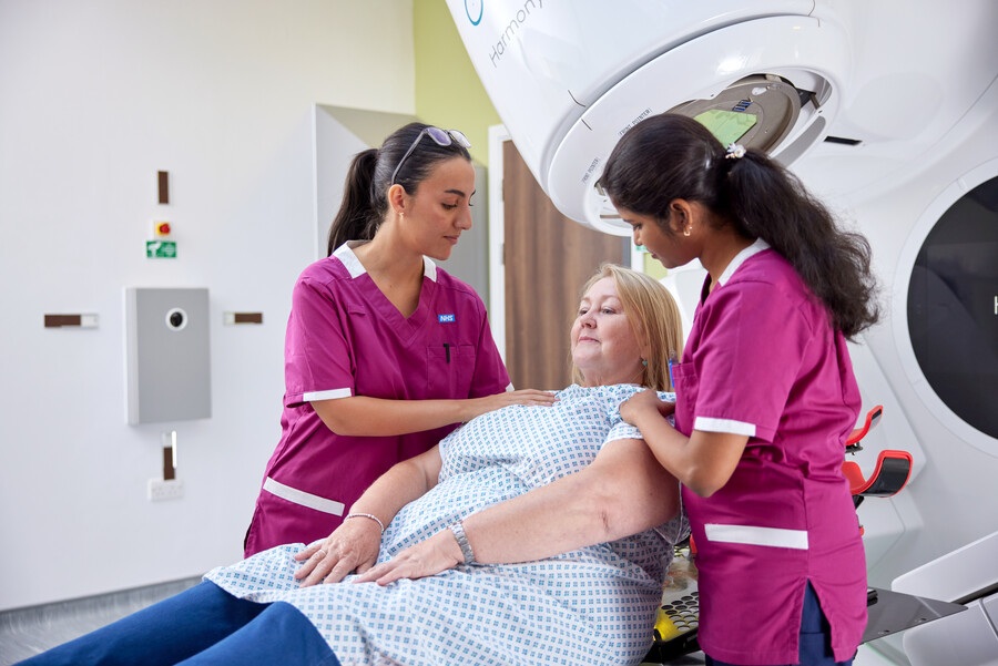 A photo of 2 radiographers treating a female patient.