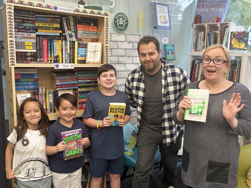 A photo of bestselling author and former doctor Adam Kay meeting children and teacher Bethan Evans from the proton beam therapy centre at The Christie.
