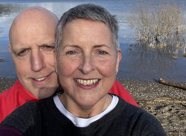 A photo of Christie patient Chris Thomasson-Dale and her husband Chris standing in front of a lake.