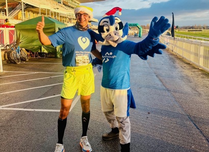 A photo of Christie consultant Rohit Kochhar with a blue bird mascot at the Liverpool Aintree half-marathon.