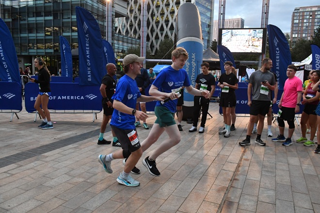 A photo of 2 male colleagues from Bromelys Solicitors running a relay race at Media City in Salford.