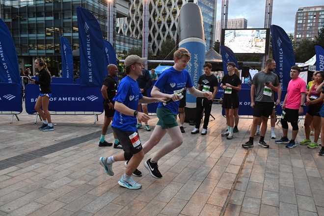 A photo of 2 male colleagues from Bromelys Solicitors running a relay race at Media City in Salford.