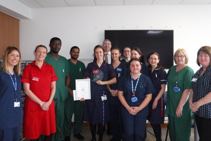A photo of the ward 11 team at The Christie receiving their You Made a Difference award from Roger Spencer, chief executive at The Christie.