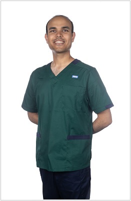 A photo of a pharmacist wearing a uniform in bottle green with navy contrast trim.