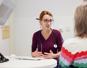 A photo of a female consultant talking to a female patient, who is out of view.