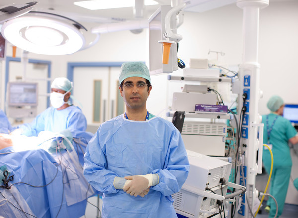 A photo of Christie consultant Professor Omer Aziz in theatre, surrounded by people carrying out surgery.