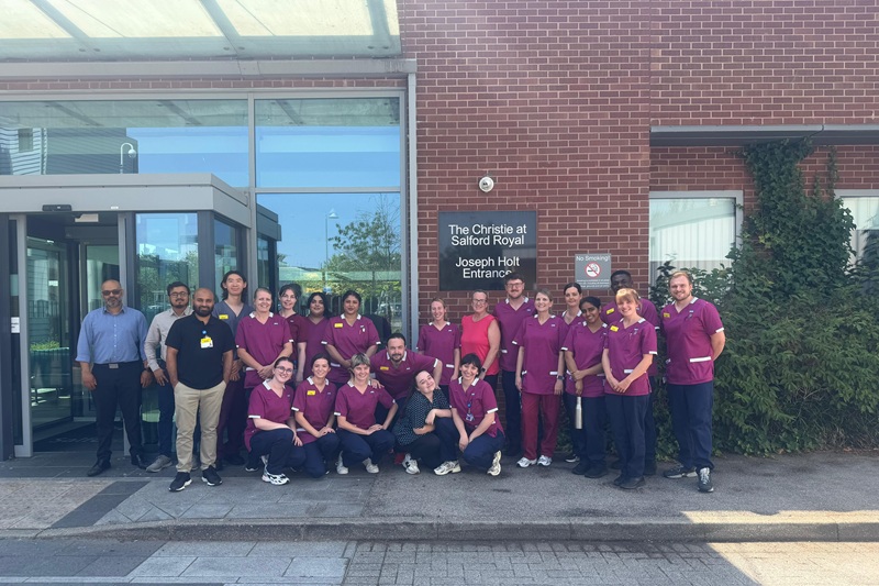 A photo of The Christie at Salford team outside the Joseph Holt entrance at Salford Royal.