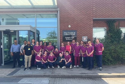 A photo of The Christie at Salford team outside the Joseph Holt entrance at Salford Royal.