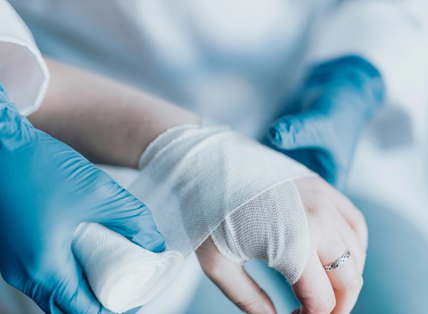 A photo of a hand being wrapped in bandages.