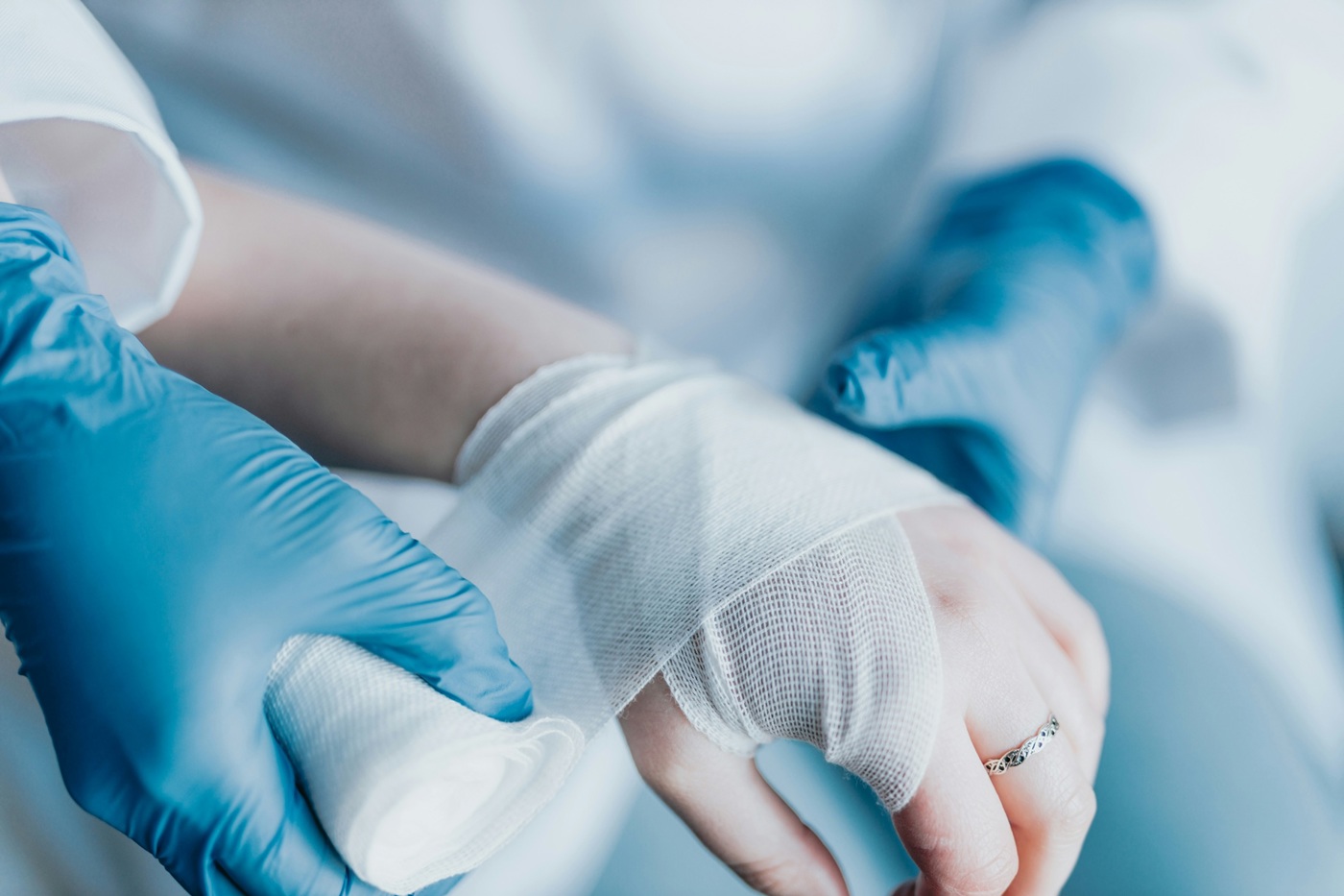A photo of a hand being wrapped in bandages.