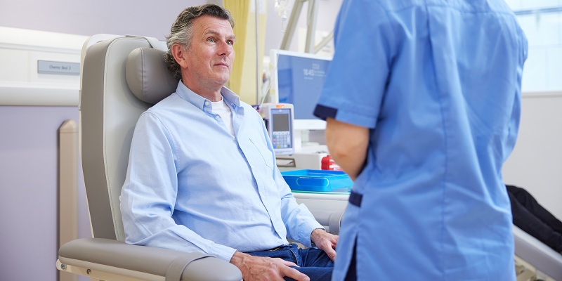 A photo of a male patient talking to a nurse.