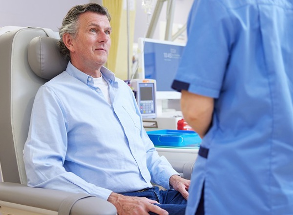 A photo of a male patient talking to a nurse.