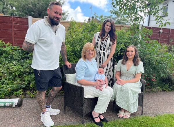 A photo of Christie patient Ann Lally, her adult children Becky and Michael, Michael's wife and their newborn baby Arthur.
