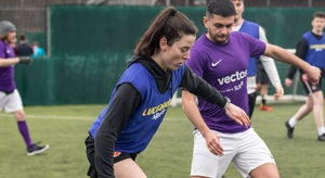 A photo of men and women playing five-aside football.