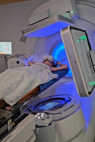A photo of Christie patient Coby Kings wearing a VR headset while he has radiotherapy.