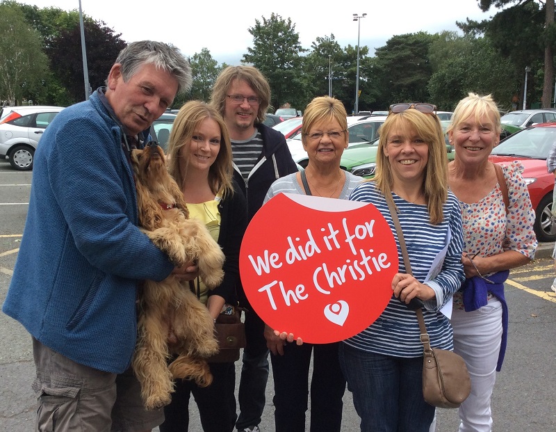 A photo of the Nantwich Christie Hospital Support Group; one member is holding a sign reading 'We did it for The Christie' and another is holding a dog.