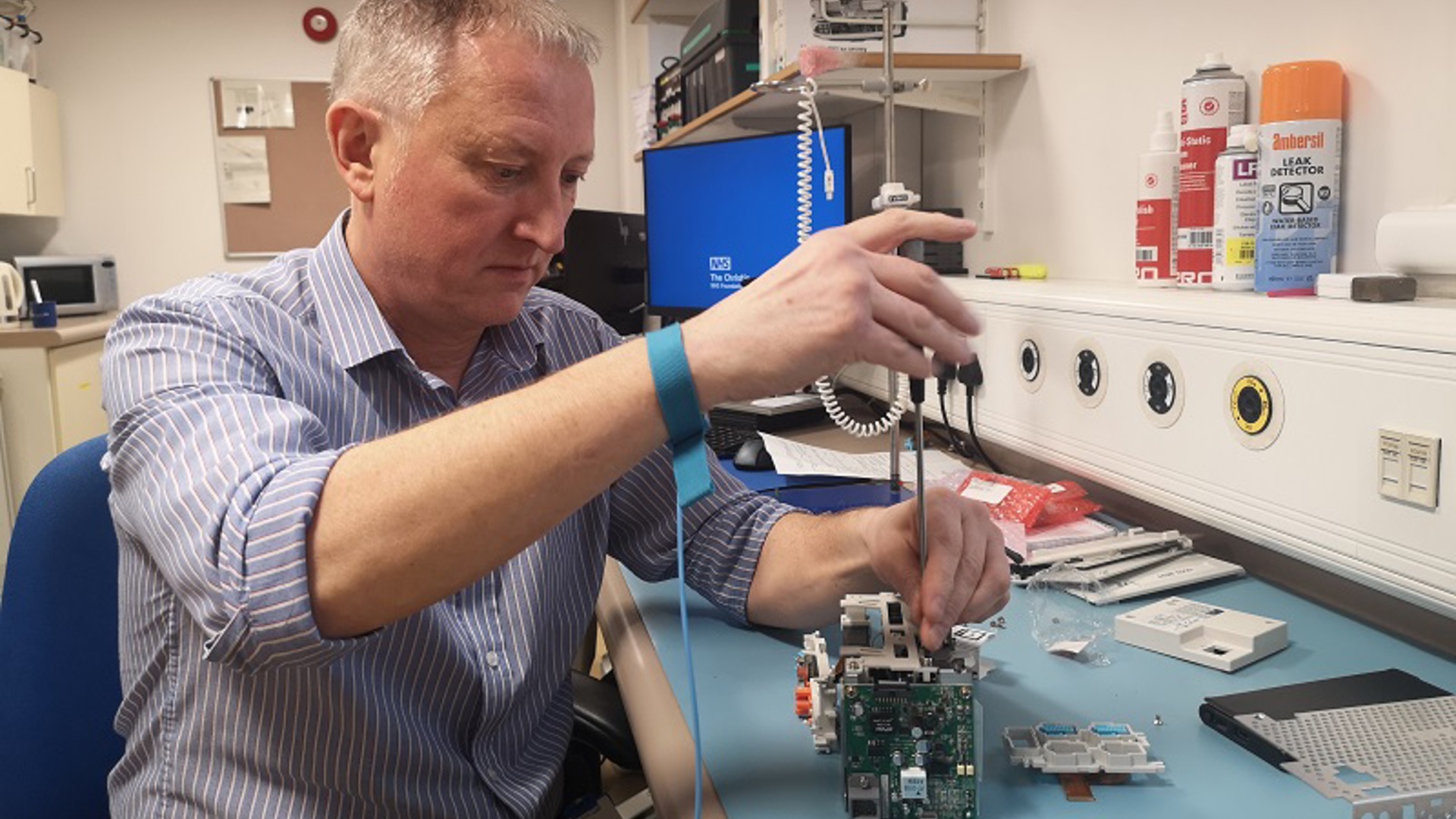 A photo of a man in the clinical engineering department at The Christie using a screwdriver on a piece of equipment.