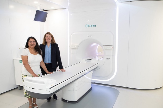 A photo of the MR-Linac first patient standing next to the MR-Linac machine with Professor Ananya Choudhury.