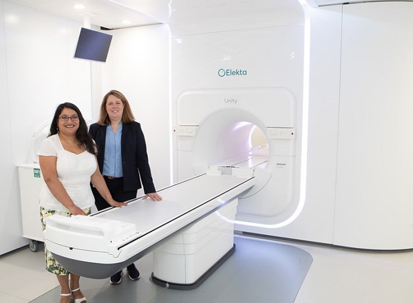 A photo of the MR-Linac first patient standing next to the MR-Linac machine with Professor Ananya Choudhury.