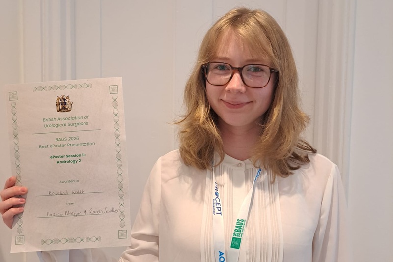 A photo of Rosalind Walsh holding a certificate for best ePoster presentation.