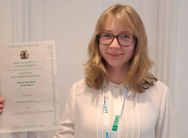 A photo of Rosalind Walsh holding a certificate for best ePoster presentation.