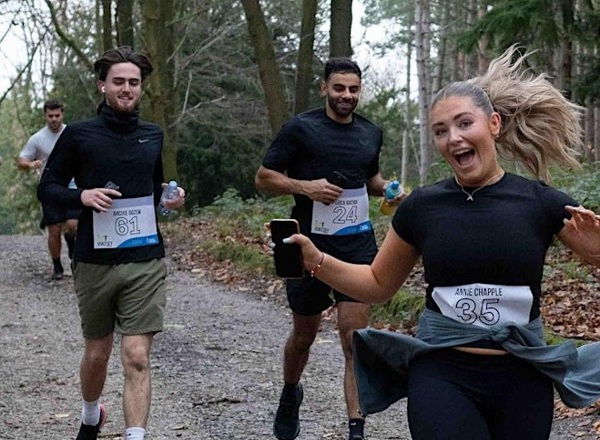 A photo of 4 young people running.