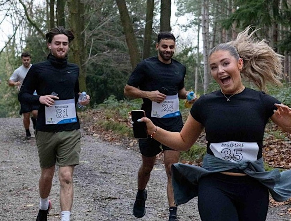 A photo of 4 young people running.