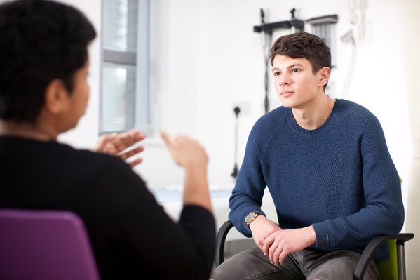 A teenage cancer patient at The Christie talking to a female doctor.