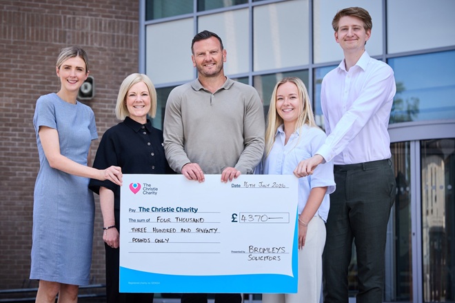 A photo of the team from Bromleys Solicitors with John from The Christie Charity holding an oversized cheque for £4,370.