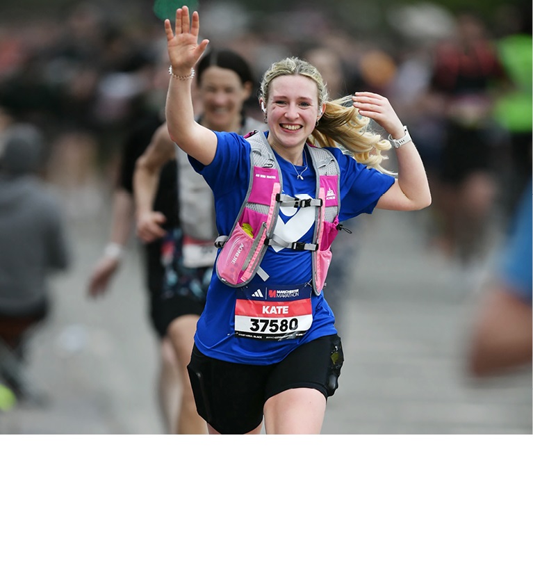A photo of a woman wearing a Christie Charity t-shirt and running a marathon.