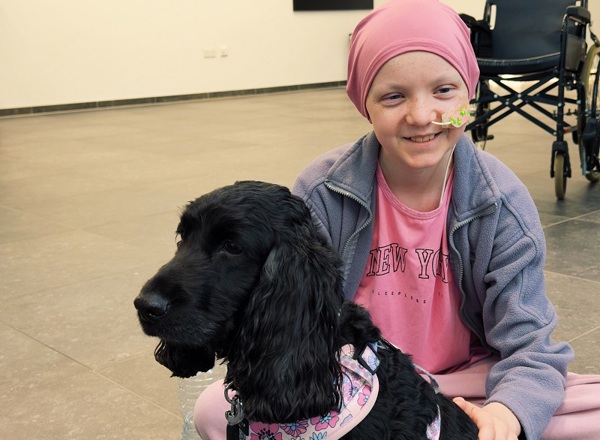 A photo of Christie patient Jaye with Lilo the black spaniel.