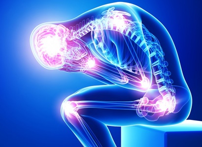A graphic of a person sat down and leaning over with their head in their hands. Their body is transparent and shows their skeleton, with areas of light on the body representing pain spots.
