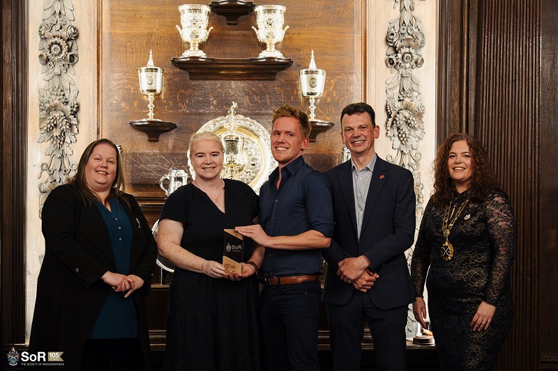 A photo of the radiotherapy clinical trials team from The Christie accepting their North West Radiography Team of the Year and UK Radiography Team of the Year awards from the Society of Radiographers.